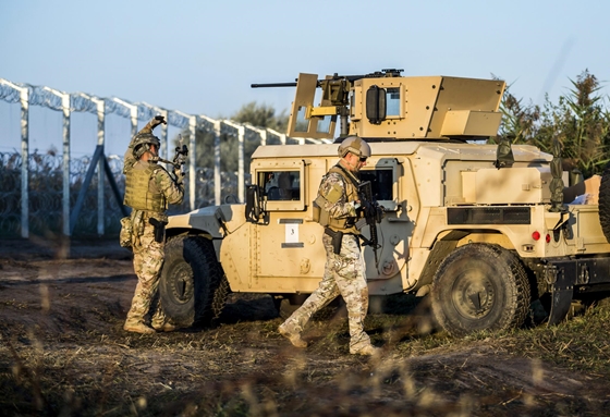 Csak d�szlet, de akkor is j� l�tni: g�pfegyveres Humveek fogadj�k a hat�rs�rt�ket